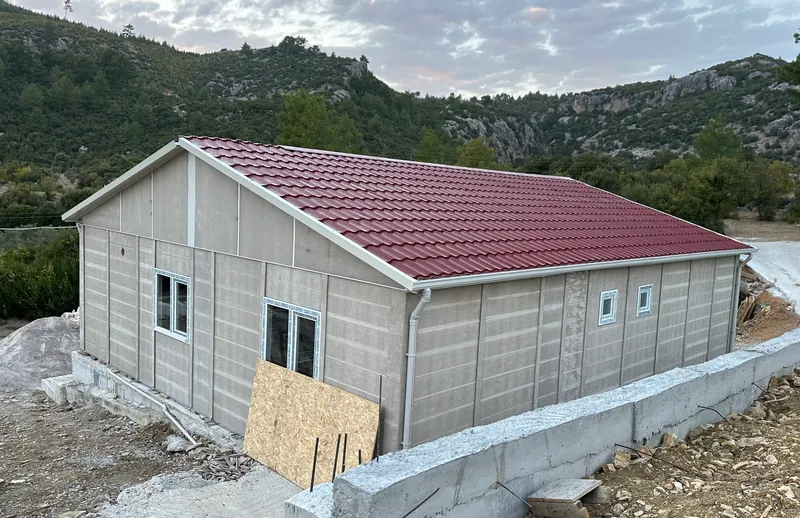 Temeli üzerinde kurulmuş, çatısı tamamlanmış, dış cephe öncesi prefabrik panel ev