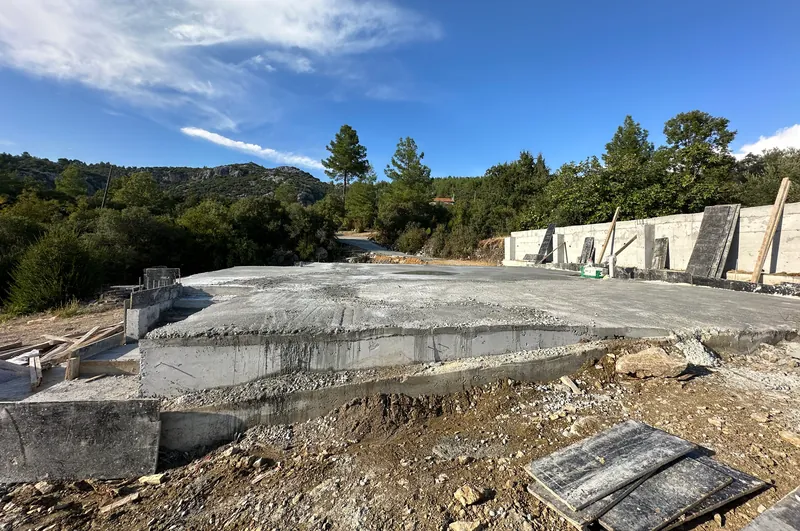 Yeni dökülmüş betonarme radye temel ve arkasında istinat duvarı